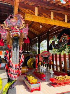 a room with a table with a person wearing a mask at Indah Damai Cottages in Sidomukti