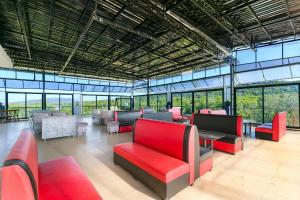 富国Ruby Hotel Phu Quoc的大房间设有红色的椅子、桌子和窗户