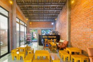 富国Ruby Hotel Phu Quoc的一间有桌椅和砖墙的房间