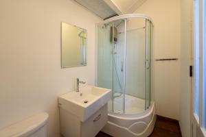 a bathroom with a sink and a glass shower at SEA BREEZE Apartment in Tân Thành (1)