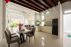 a kitchen and dining room with a table and chairs at SEA BREEZE Apartment in Tân Thành (1)
