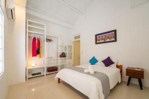 a white bedroom with a bed and a window at SEA BREEZE Apartment in Tân Thành (1)
