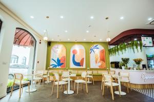 a room with tables and chairs in a restaurant at Palette Collect's Boutique Hotel Ha Long in Ha Long