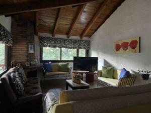 a living room with couches and a flat screen tv at La cabaña Gaby in Mazamitla +76 photos