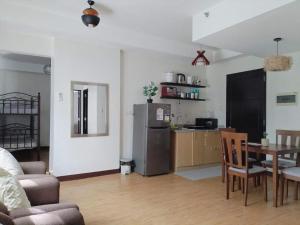a living room with a table and a kitchen with a refrigerator at BNB Staycation and Condo Rental in Cagayan de Oro