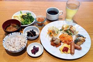 a table with a plate of food and a glass of beer at Hotel Roco Inn Okinawa in Naha