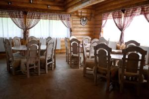 a dining room with tables and chairs and windows at Pensiunea Laricea in Vatra Dornei