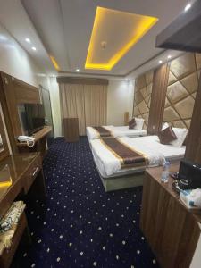 a hotel room with two beds and a television at فندق عين دره in Sawdāʼ