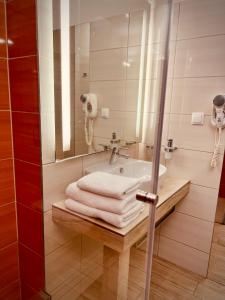 W łazience znajduje się umywalka, lustro i ręczniki. w obiekcie Hotel Arkadia Jelcz-Laskowice w mieście Jelcz