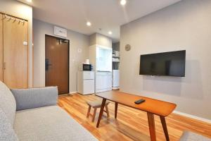a living room with a table and a tv on a wall at ZJ301 Hanama301 The Skytree Residence A Newly Home by Tokyo Iconic Landmarks in Tokyo