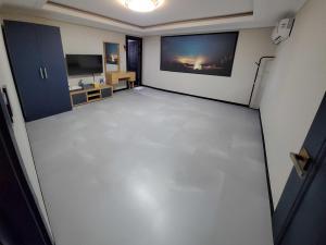 an empty room with a white floor in a room at Hotel Cheongdam in Mokpo