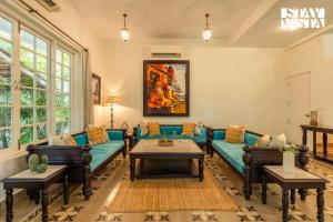 a living room with a couch and a table at StayVista at A Portuguese Tale - Pool, Bar & BBQ in Assagao