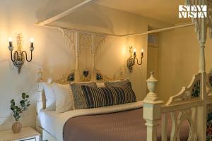 a bedroom with a white bed with a canopy at StayVista at A Portuguese Tale - Pool, Bar & BBQ in Assagao