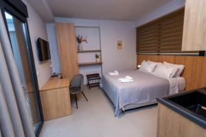 a small room with a bed and a television at Empress Luxury Residences in Volos