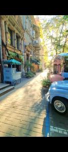 an old car parked on a street next to a building at Old Town #Menorah #MostCity in Dnipro