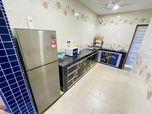 a kitchen with a refrigerator and a counter top at Cozy Kulai Retreat 5Min AeonPalm Resort15Min Senai airport in Kulai