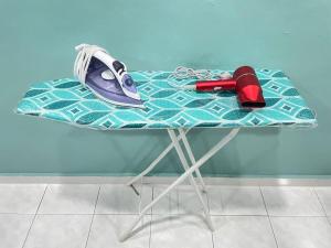 a table with a ironing board with a ironing at Cozy Kulai Retreat 5Min AeonPalm Resort15Min Senai airport in Kulai