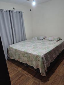 a bedroom with a bed with a blanket and curtains at Casa DIMAS in São Pedro +13 photos