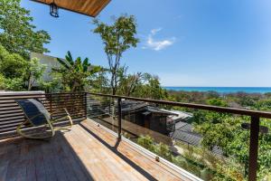 a deck with a chair sitting on top of it at Ocean Apartments- Walk to the beach in Santa Teresa Beach