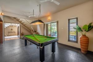a pool table in a living room with at SaffronStays Sommeliers Choice in Gangāpur