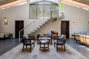 a living room with chairs and a staircase at SaffronStays Sommeliers Choice in Gangāpur