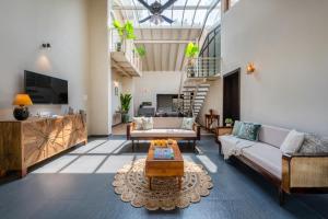 a living room with a couch and a coffee table at SaffronStays Sommeliers Choice in Gangāpur