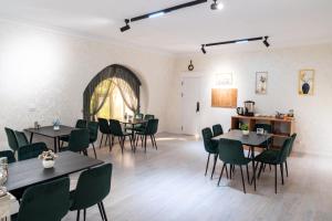a dining room with tables and green chairs at Status Inn Hotel in Samarkand
