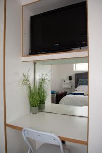 a room with a desk with a tv on a mirror at Place of Grace in Cape Town +20 photos