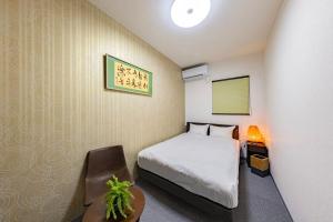 ein Hotelzimmer mit einem Bett und einem Stuhl in der Unterkunft ぷらむならまち Momiji邸 in Nara + 35 Fotos
