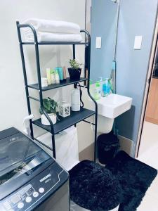 a bathroom with a towel rack and a sink at Jazz Cozy Abode in Manila