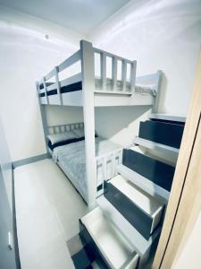 a small bedroom with a bunk bed and stairs at Jazz Cozy Abode in Manila +32 photos