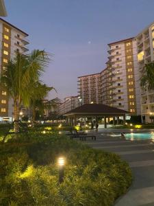a night view of a hotel with a pool and buildings at Jazz Cozy Abode in Manila