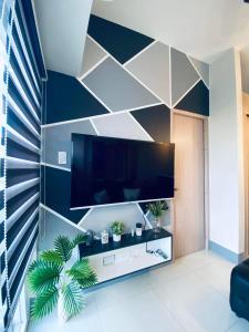 a living room with a large flat screen tv on a wall at Jazz Cozy Abode in Manila +28 photos