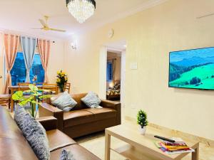a living room with a couch and a tv on a wall at Elegant 3BHK Fully Furnished and Equipped Apt near Hitec City by EVARA SUITES in Hyderabad