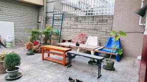 a patio with a bench and a table and chairs at 東海獨角獸 in Longjing