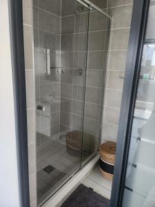 a bathroom with a glass shower with a toilet at Cozy home in Pretoria