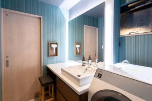 a bathroom with a sink and a washing machine at 貸し切り宿 世紡 YOTSUMUGI sakazuki and iyasaka in Yufuin