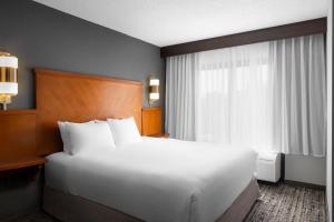 Un dormitorio con una gran cama blanca y una ventana. en Hyatt Place Chantilly Dulles Airport South, en Chantilly