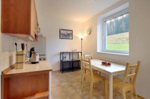 a kitchen and dining room with a table and a window at Apartment Michaela in Pec pod Sněžkou