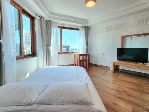 a bedroom with a bed and a flat screen tv at Seogwiporto in Seogwipo