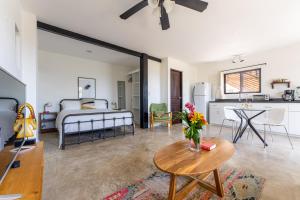 a living room with a bed and a table with flowers at Ocean Apartments- Walk to the beach in Santa Teresa Beach +279 photos
