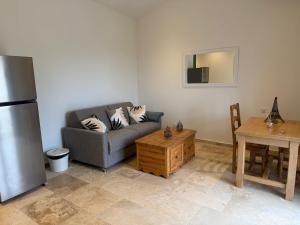 ein Wohnzimmer mit Couch und Tisch in der Unterkunft Le Cœur du Village in Sainte-Cécile-les-Vignes