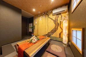 ein Schlafzimmer mit einem Baumbild an der Wand in der Unterkunft ぷらむならまち Sakura邸 in Nara