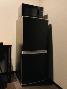 eine Mikrowelle auf einem Kühlschrank in der Unterkunft ぷらむならまち Sakura邸 in Nara + 36 Fotos