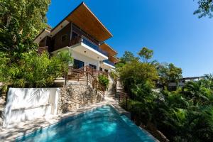 a house with a swimming pool in front of a house at Ocean Apartments- Walk to the beach in Santa Teresa Beach