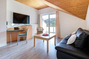 a living room with a couch and a table at Apartment Landhotel Zum Storchennest in Bann