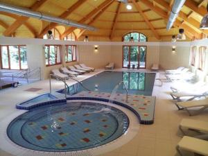 Una gran piscina en un edificio con sillas. en Fenyves Hotel Békéscsaba, en Békéscsaba