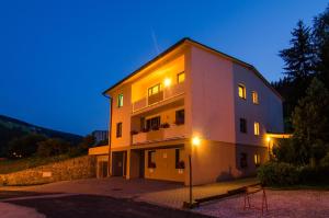 a large white building with its lights on at Apartment Michaela in Pec pod Sněžkou