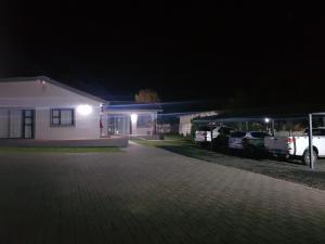 a house with two cars parked in front of it at night at MediStay Self Catering Accommodation in Bethlehem
