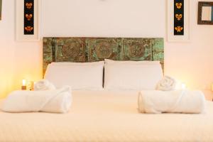 滨海托萨SeaHomes Vacations - Centric Apt 100m Beach and PKG的一间卧室,床上配有两张毛巾和两张蜡烛